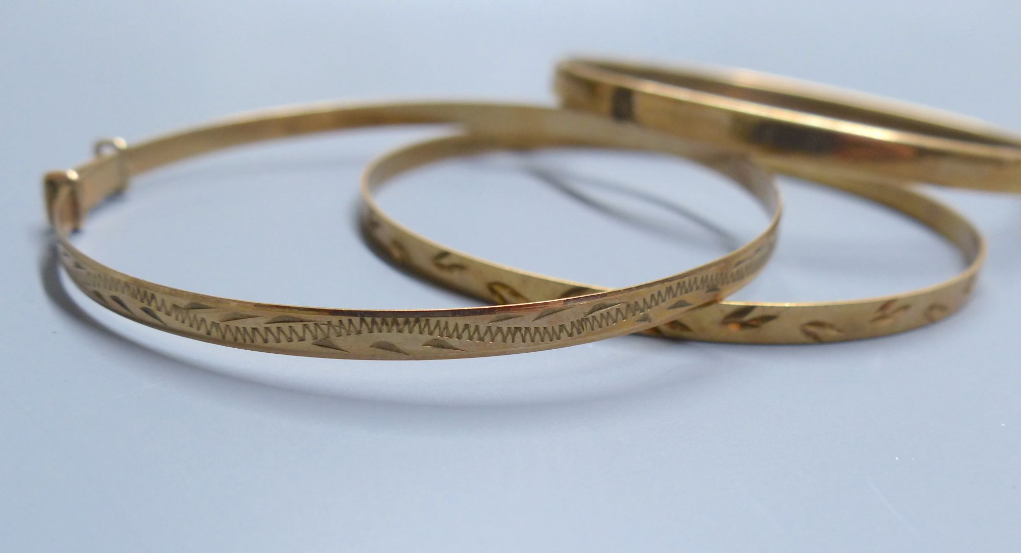 Three modern 9ct gold bangles,